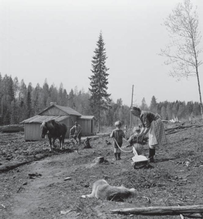 Une famille d'évacués, réfugiée dans le sud de la Finlande, travaillant la terre..jpg
