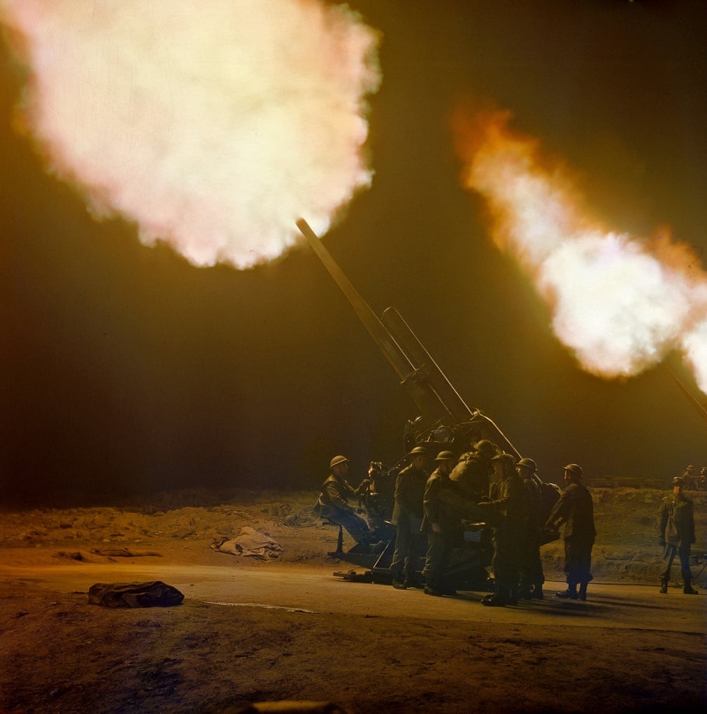 Une batterie de canons anti-aériens de 3,7 pouces tirant de nuit.jpeg